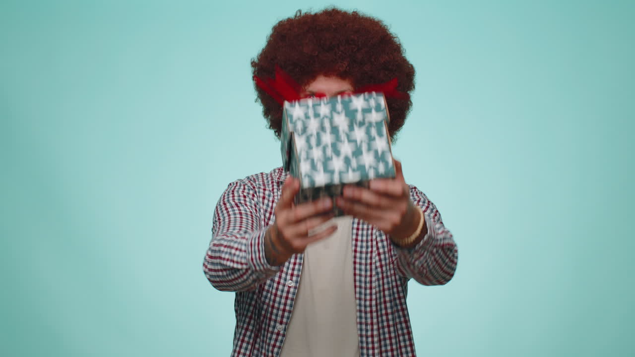 Uomo sorridente che presenta una scatola regalo di compleanno, allunga le mani, offre un regalo incartato come bonus carriera