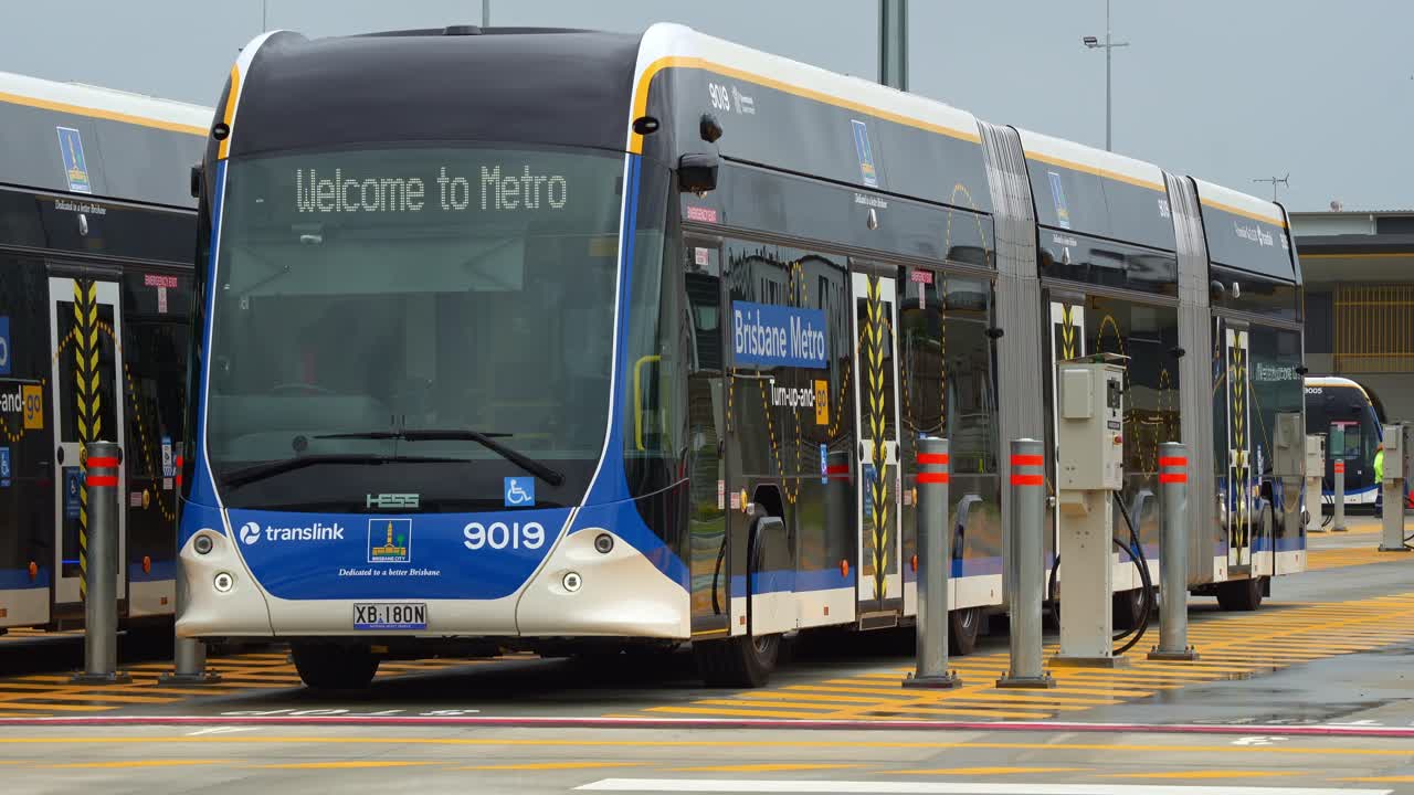 Close up shot of sleek, electric bi-articulated Brisbane Metro Bus parked at the off-peak slow charging station in Rochedale depot, innovative bus rapid transit system in Queensland.