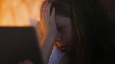 Cute-little-girl-makes-facepalm-gesture-looking-at-tablet