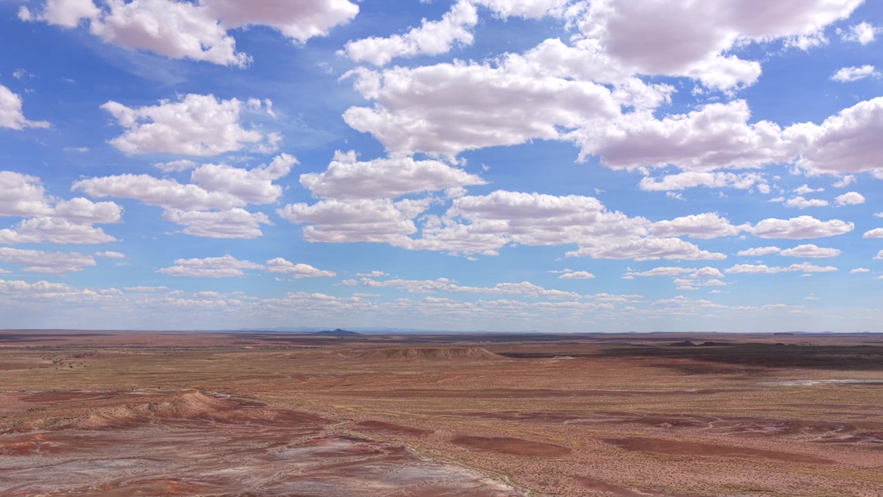 En filmisk 4k droneflyvning svæver over den vidtstrakte Arizona ørken-skyline. Det jævne luftperspektiv afslører det barske terræn og en stor sydvestlig horisont under en stor skyet himmel.