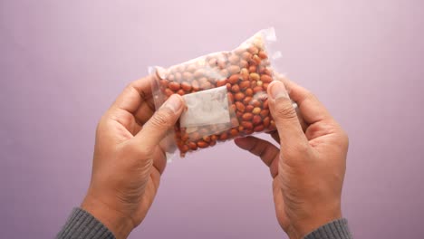 men holding a packet of peanuts ,