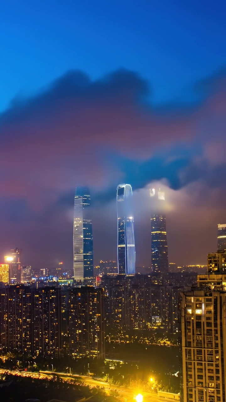 Timelapse de Nuvens se Movendo Sobre Arranha-Céus Iluminados à Noite