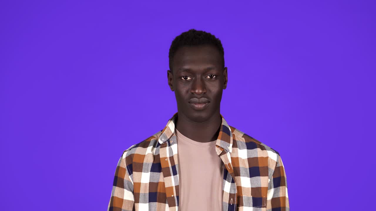 hombre alegre en camisa a cuadros invitando, agitando las manos, ofreciendo unirse. joven hombre negro gesto sobre fondo azul