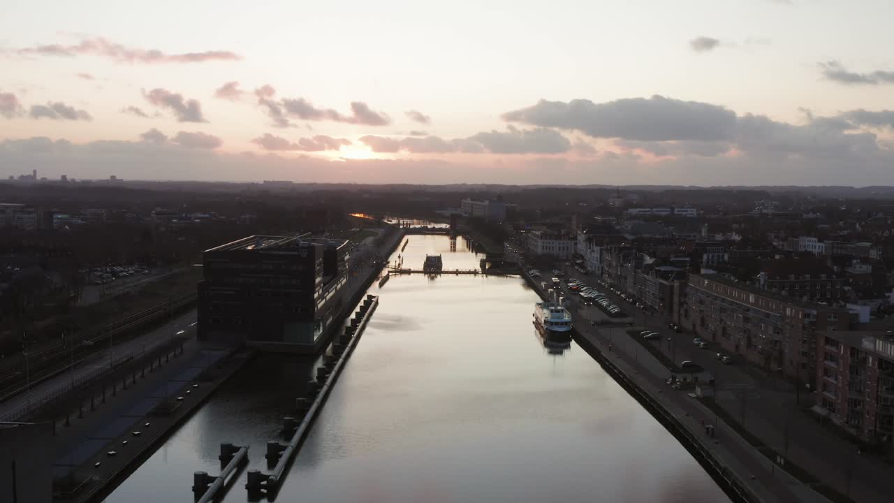 Drone flying forwards over a man made canal through a historical city