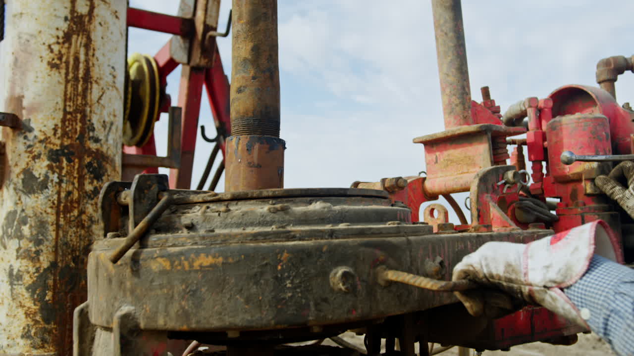 Man arranges the details of the equipment for drilling oil. Professional working at the site for production natural resources.