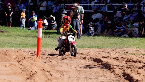 child motocross rider racing on dirt track