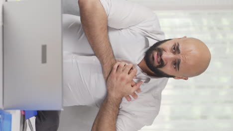 Vertical-video-of-Home-office-worker-man-having-a-heart-attack.