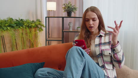 una joven triste usa su teléfono móvil, navega, pierde, se sorprende repentinamente de los malos resultados de la lotería.