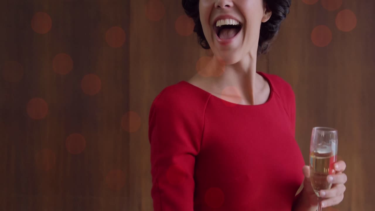 animación de puntos de luz sobre una mujer caucásica sonriente agitando con champán