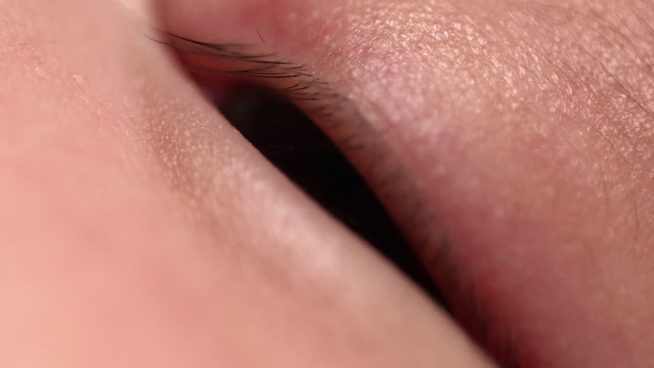 눈을 열고 닫는 신생아는 빛과 주변에서 움직이는 모든 것에 반응합니다.