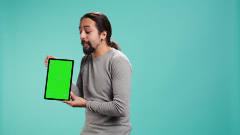 hombre feliz con una tableta de pantalla verde, haciendo recomendaciones