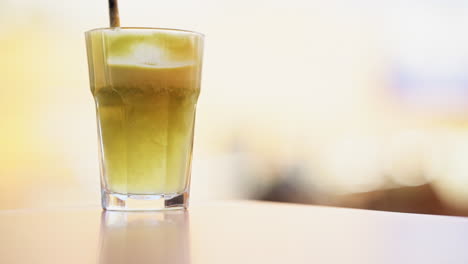 jugo recién exprimido en un vaso de vidrio mezclado con una pajita en cámara lenta