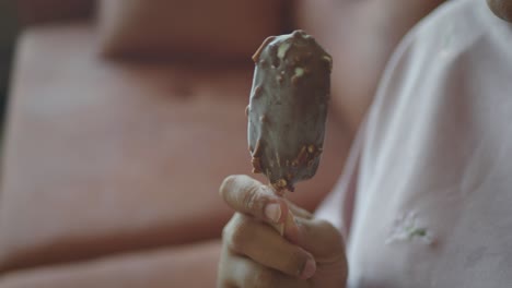 person holding a chocolate almond ice cream bar