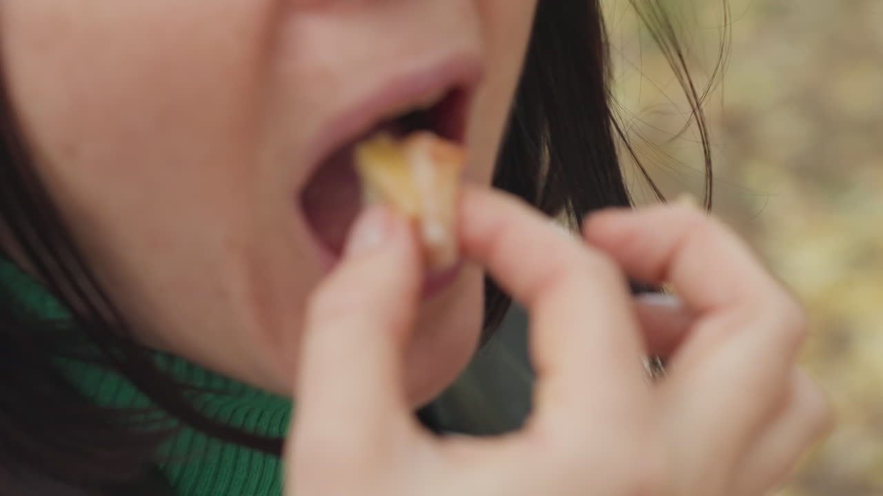 Primer plano de una mujer blanca realizando un ritual de cuidado labial, aplicando bálsamo en el labio inferior con la yema del dedo, presión suave y ligero fruncimiento, detalle de la textura íntima, luz natural y fondo suave de otoño, personal y natural
