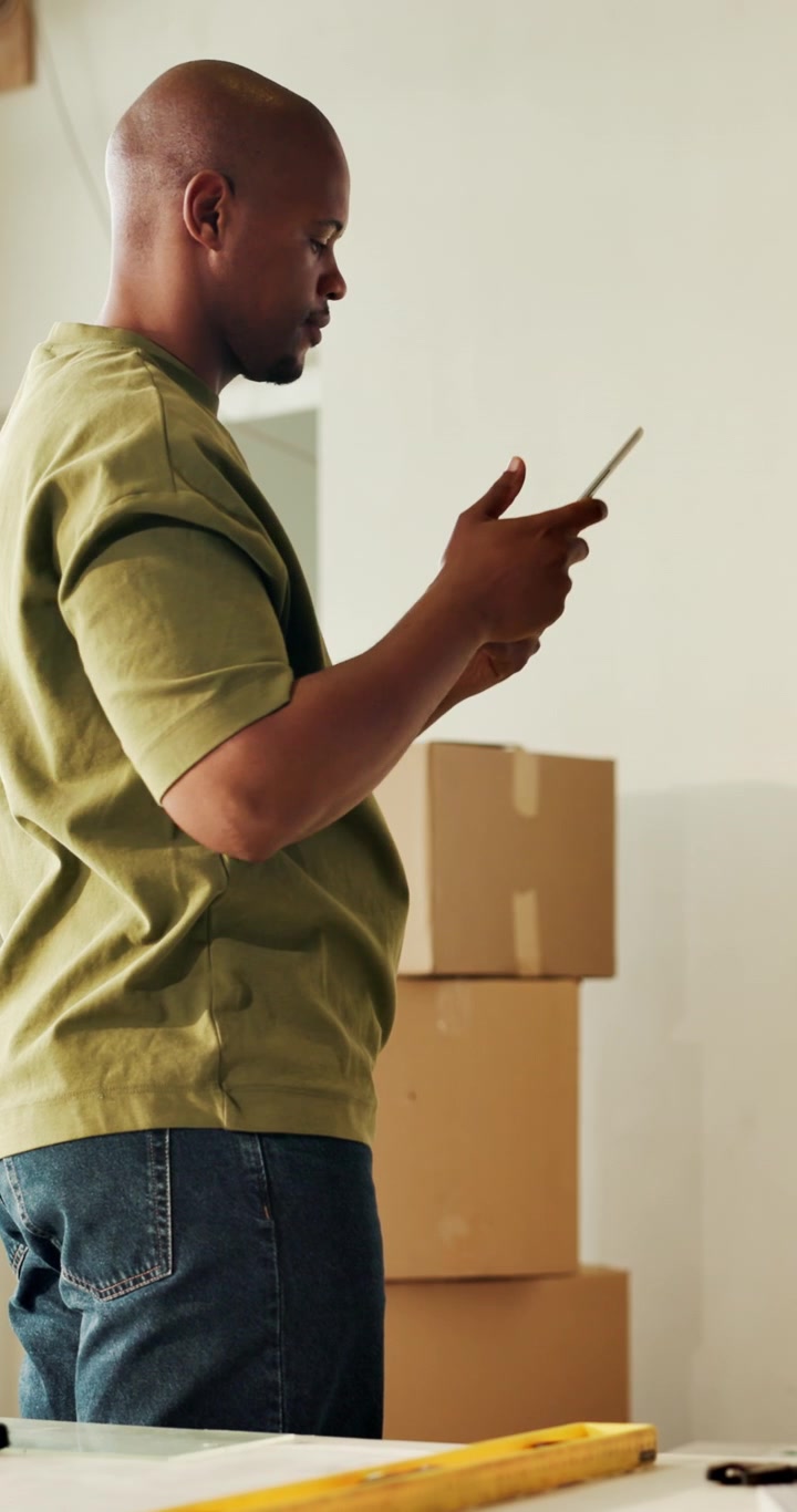 Man Using Smartphone While Moving Into New Home