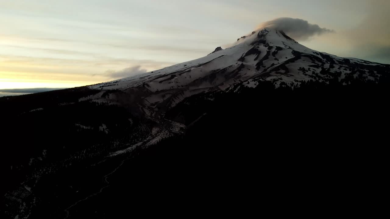 US, Oregon, Mt Hood, , 2025-05-10 - Drone view of Mt Hood in northern Oregon at sunset with clouds curling over the peak of the mountain in the Spring.