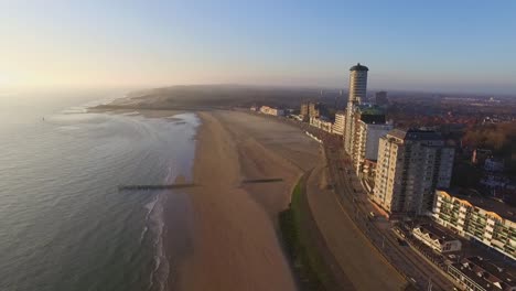 Aerial:-The-boulevard,-beach-and-city-of-Vlissingen-during-sunset