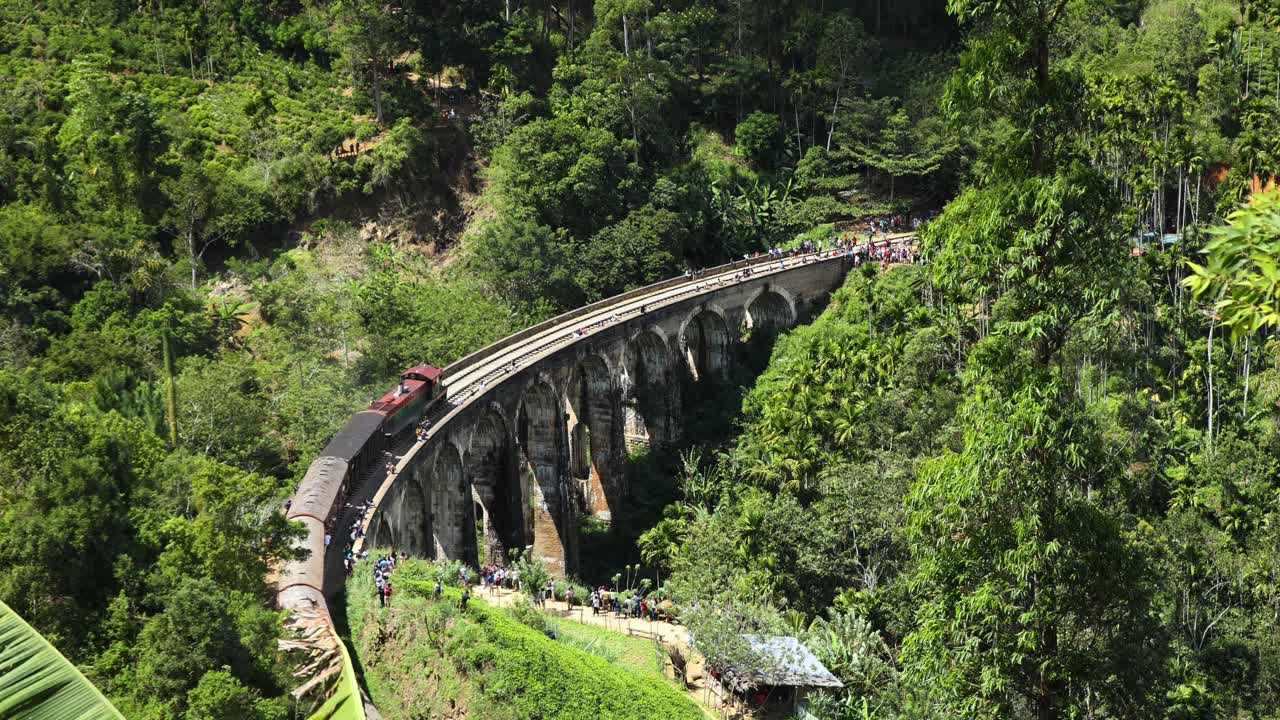 9개의 아치 역사적 다리, 엘라 스리랑카를 건너는 빈티지 기차의 슬로우 모션 샷
