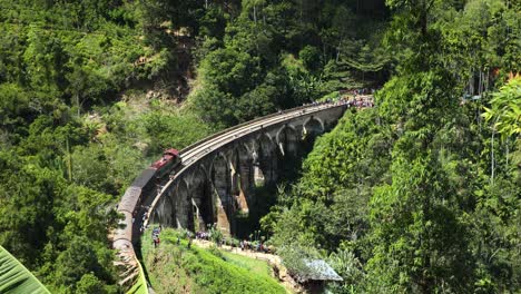 slow motion shot of vintage train crossing nine arches historical bridge, ella sri lanka