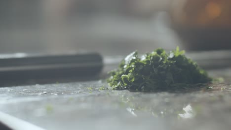 pizza maker cutting parsley in kitchen