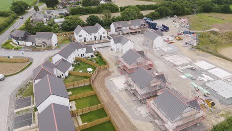 aerial view of half built new homes in rural development in the uk, surrounded by fields and construction activity
