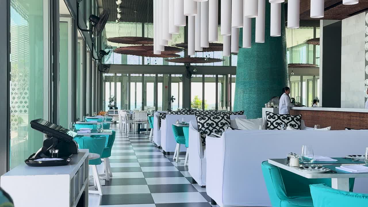 태국 푸켓에 있는 럭셔리 레스토랑으로, 현대적인 디자인과 르키즈 색 조명과 자연 조명을 선보이고 있습니다.