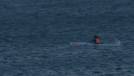 vista aérea de piragüista profesional cabalgando muy rápidamente en el mar entrando en la noche, cascais, portugal