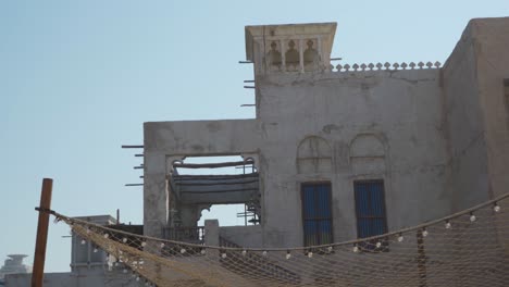 casas tradicionales restauradas en el barrio histórico de al fahidi con dosel de follaje en dubai, emiratos árabes unidos