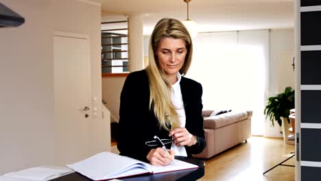 business woman standing and writing in a notebook