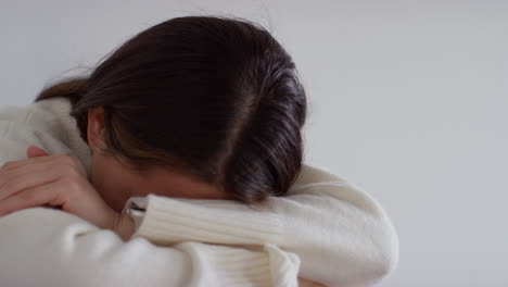 Stressed-Or-Anxious-Woman-Suffering-With-Depression-And-Anxiety-Leaning-Against-Wall-Sitting-On-Floor-At-Home-With-Head-In-Hands