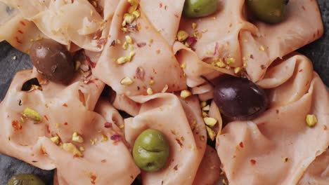 ham italian mordatella, man slices of traditional italian antipasti mortadella sausage on a wooden cutting board, close up macro of chicken or turkey jamon, fat breakfast dish.