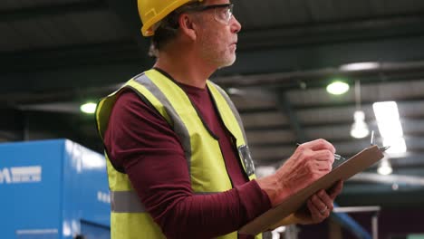 Worker-examining-while-writing-on-clipboard