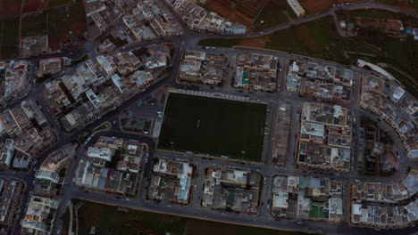 Vista-De-Pájaro-Sobre-El-Campo-De-Fútbol-Al-Atardecer-En-Dingli,-Malta---órbita-De-Drones