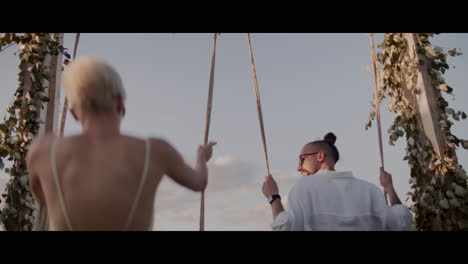 couple enjoying a swing at sunset