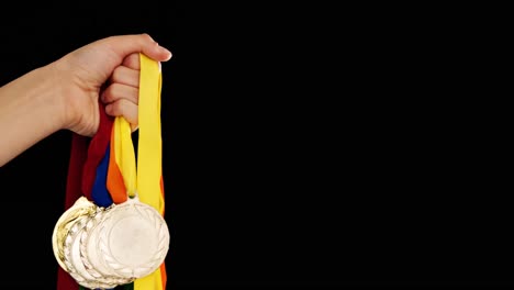 con medallas en la mano contra un fondo negro 4k
