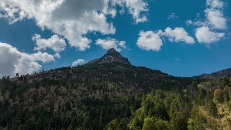 Hyperlapse-Des-Gipfels-Des-Nevado-De-Colima-An-Einem-Sonnigen,-Bewölkten-Tag,-Mit-Sonnenstrahlen,-Die-Die-Kiefernwälder-Erhellen