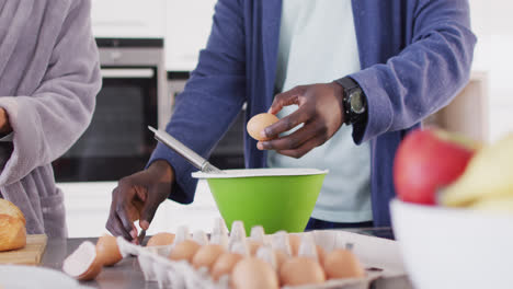 Video-of-midsection-of-african-american-couple-preparing-breakfast-together-in-kitchen