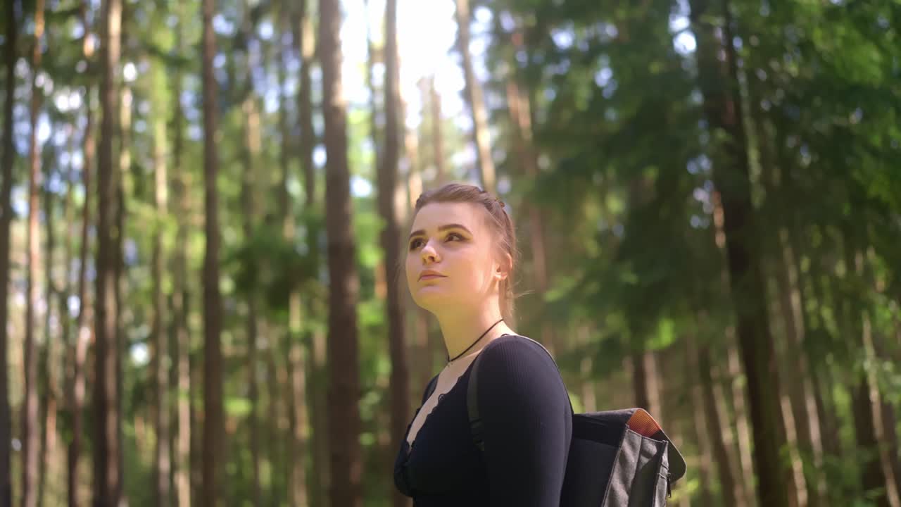 una joven hermosa está explorando el bosque de primavera en un día soleado