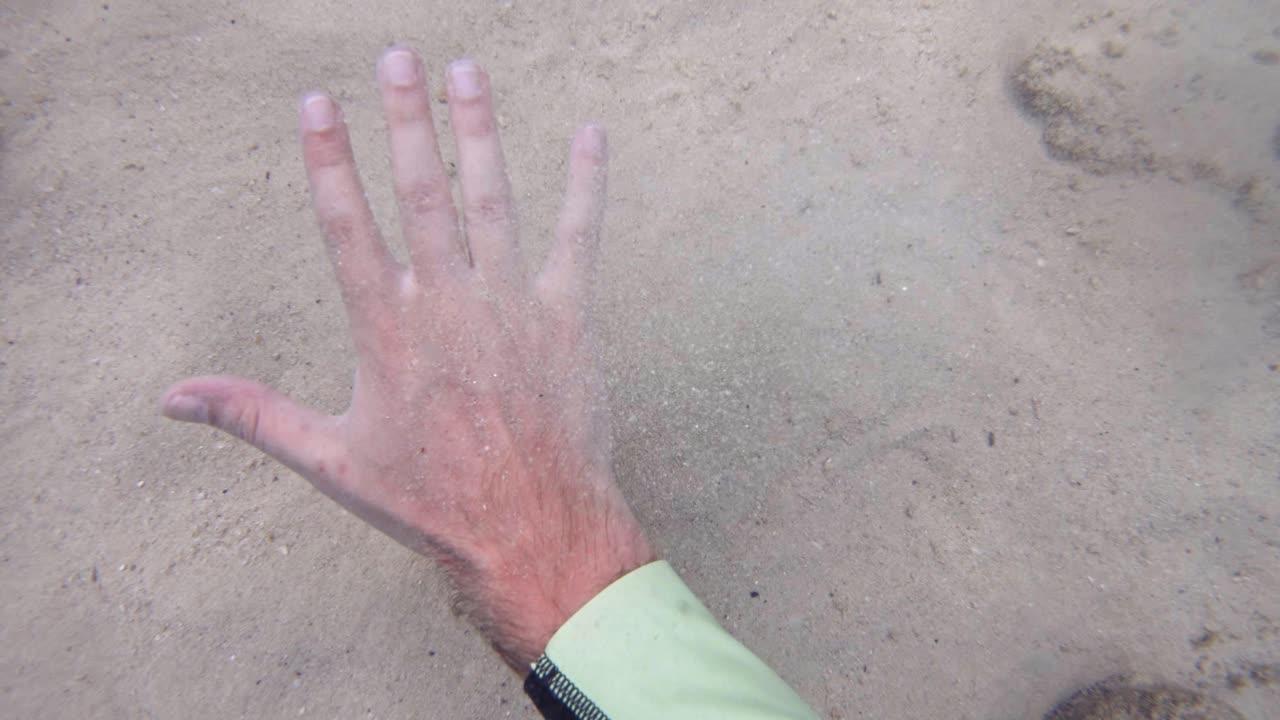 바다 플로어의 모래 바닥을 치는 손, 수중