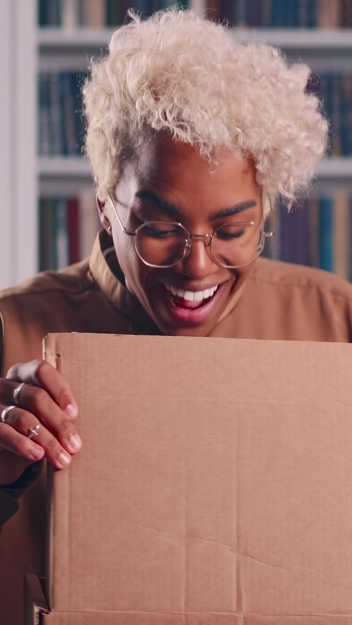 African american student happily unboxing delivered package at home office