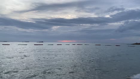 Relaxing-view-of-the-movement-of-gentle-waves-and-the-sun-disappearing-below-the-horizon,-Pattaya-,-Thailand