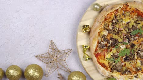 flat lay of pizza spinning 360 degree rotation on wooden salver, christmas decorations around.