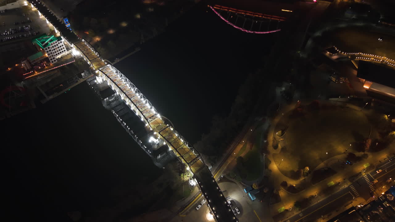 Aerial view tilting over the illuminated bridges of Nashville, night in USA