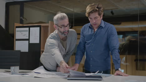 two middle-aged architects brainstorming in the office