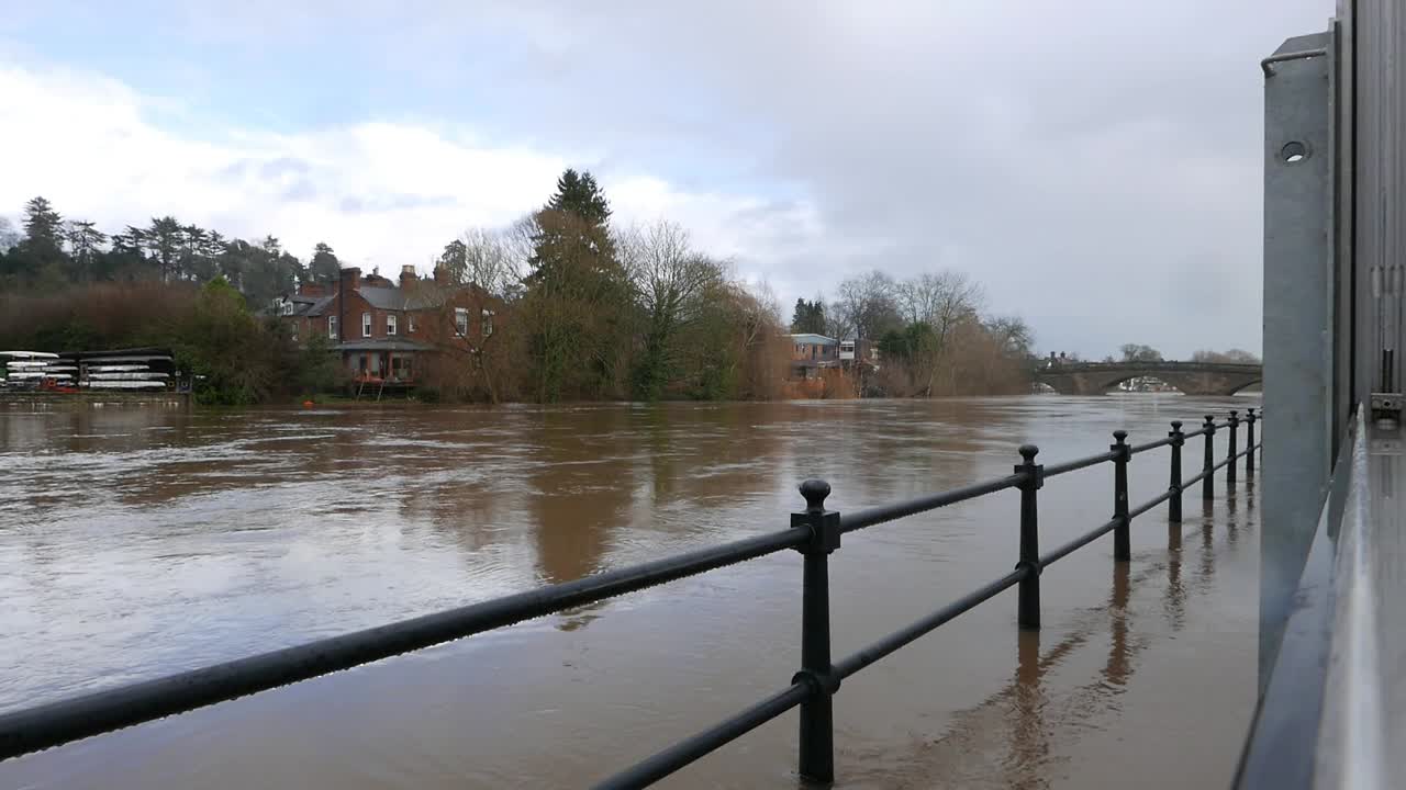 Fast flowing floodwater in the River Severn at Bewdley, with more rain falling