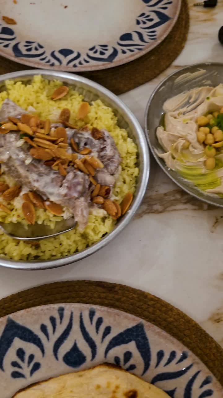 Pengambilan gambar vertikal hidangan domba Mansaf tradisional dengan saus jameed, masakan Yordania
