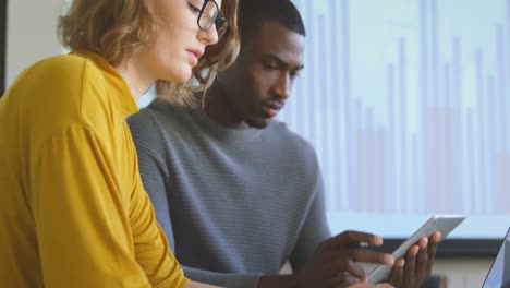 Young-mixed-race-business-colleagues-working-on-laptop-and-digital-tablet-in-modern-office-4k