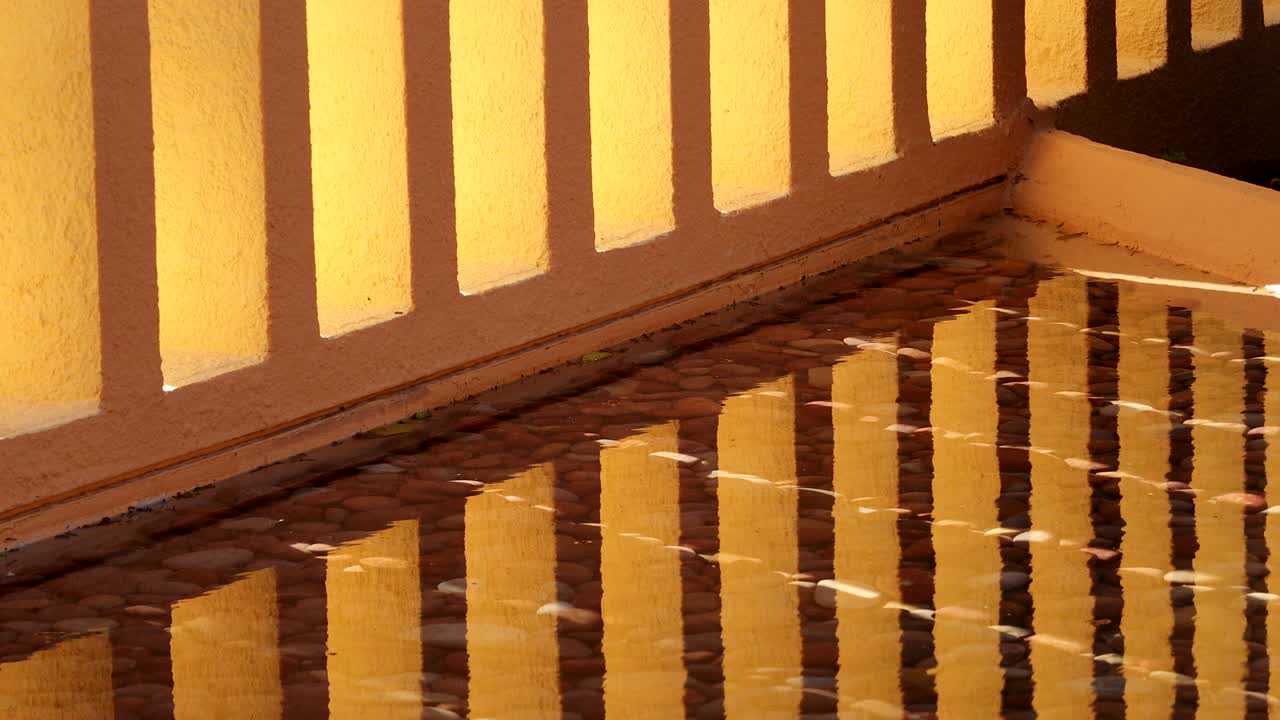 Patrones arquitectónicos de pilares naranjas reflejados en el agua