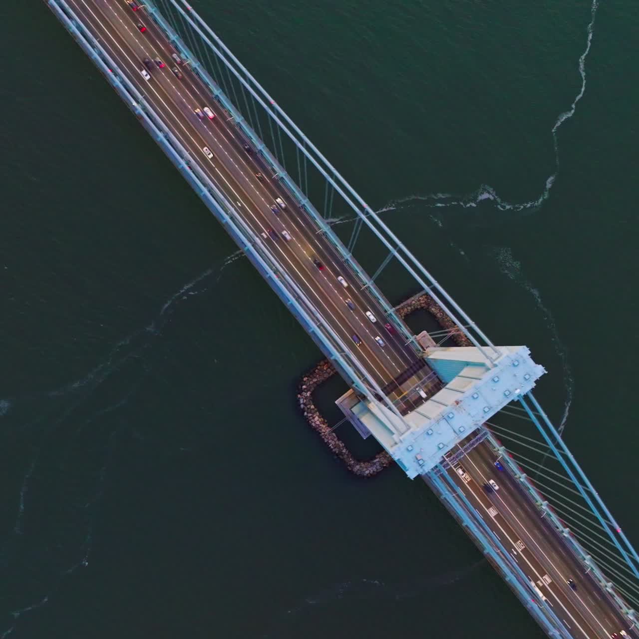 Massive huge bridge over the deep river. View from top on the bridge with transport moving quickly