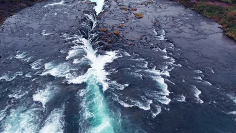 Aéreo:-Siguiendo-El-Río-Que-Conduce-A-La-Cascada-De-Bruarfoss-En-El-Sur-De-Islandia,-Que-Es-Muy-Pintoresca-Con-La-Hermosa-Cascada-Azul-De-Caídas-En-La-Piscina-De-Abajo